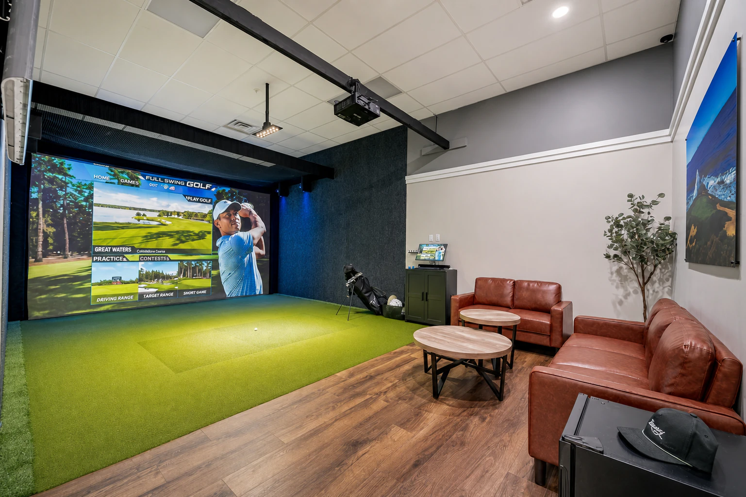 Golfer playing in a private Full Swing simulator bay at Rozay Golf